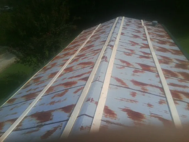 Rusted metal roof panels with new wood purlins before replacement — Storm Damage Roof Repair in League City by Roofing Brothers