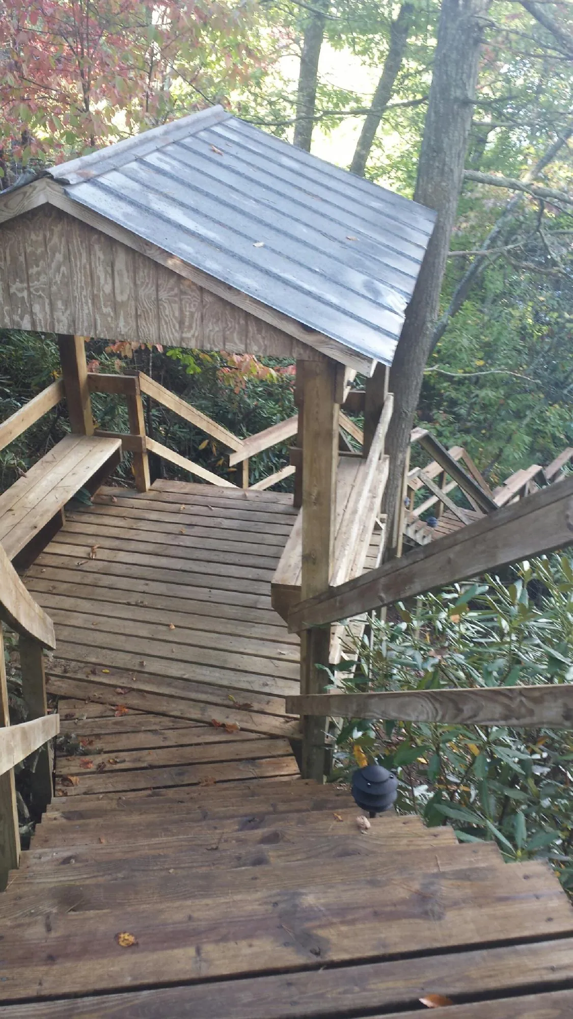 Metal roofed shelter over wooden steps on a wooded walkway — Skylight Repair & Installation work by our crew in League City