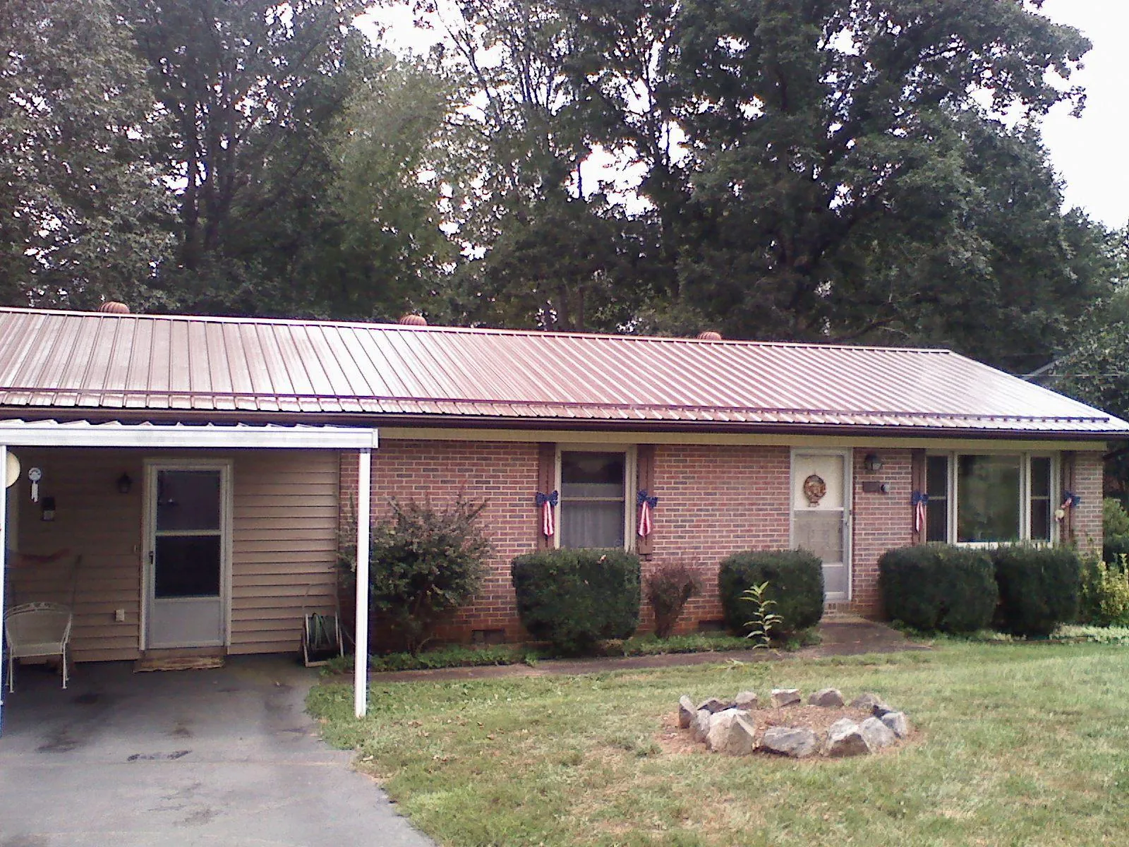 Bronze metal roof and carport on a brick ranch home — Roof Repair work by our crew in League City