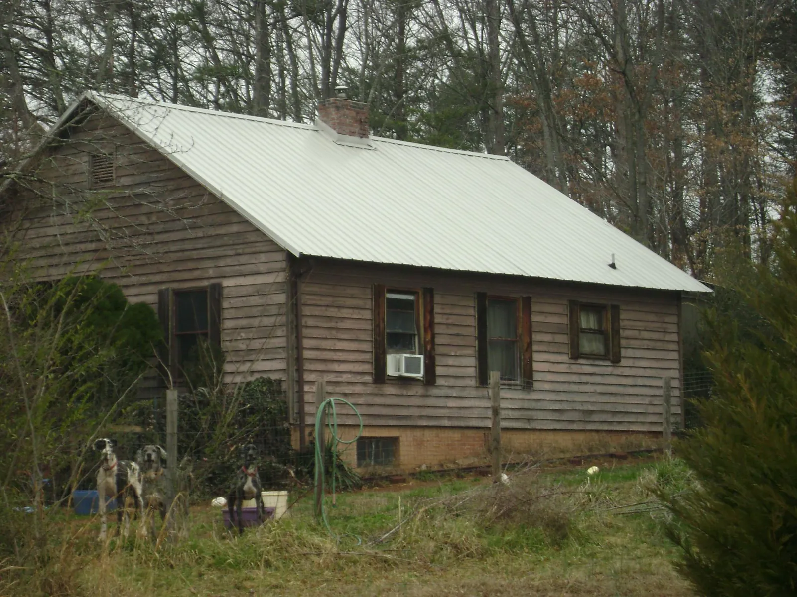 White metal roof on an old wood sided farmhouse, from a Asphalt Shingle Roof Repair job in League City